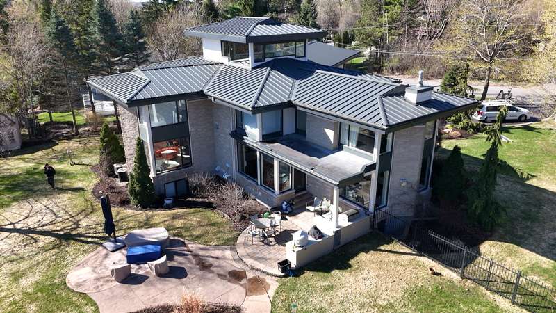 Aerial establishing shot of modern house with metal roof