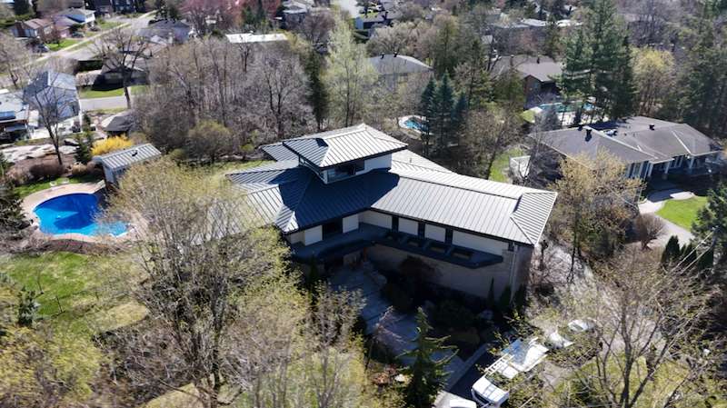 Aerial orbit of modern home with backyard pool, Kanata
